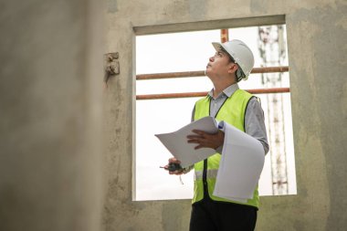 Mühendisler inşaat projelerini denetliyor ve konut binalarının duvarlarının ve temellerinin inşaatını denetliyor ve denetliyor