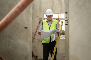 Mühendisler inşaat projelerini denetliyor ve konut binalarının duvarlarının ve temellerinin inşaatını denetliyor ve denetliyor