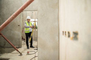 Mühendisler inşaat projelerini denetliyor ve konut binalarının duvarlarının ve temellerinin inşaatını denetliyor ve denetliyor