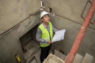 Mühendisler inşaat projelerini denetliyor ve konut binalarının duvarlarının ve temellerinin inşaatını denetliyor ve denetliyor