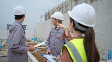 Mühendis ve mimari grupları bina duvarları ve konut binalarının temellerinin inşaatını denetler ve denetler.