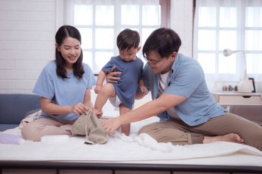 Banyodan sonra mutlu anlar, Asyalı çocuklar ve ebeveynler krem, pudra ve kostüm sürerken eğleniyorlar.