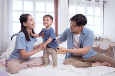 Banyodan sonra mutlu anlar, Asyalı çocuklar ve ebeveynler krem, pudra ve kostüm sürerken eğleniyorlar.