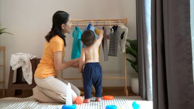 Anne ve küçük çocuk sabahları evde duş alıp giyiniyorlar.