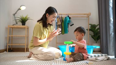 Annesiyle oynaşıp kahvaltı yapan küçük çocuk onu yıkamadan önce besliyor.