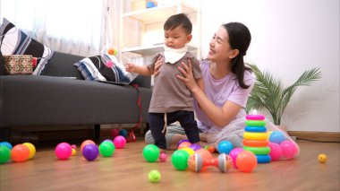 Evde tatildeyken, bir anne küçük bir çocukla ilgilenir.
