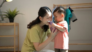 Anne ve küçük çocuk sabahları evde duş alıp giyiniyorlar.