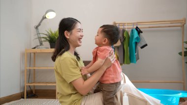 Annesiyle kahvaltı yapan küçük çocuk onu yıkamadan önce besliyor.