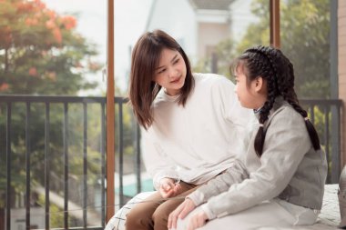 Eskrim kıyafeti giymiş bir kız, anneleriyle birlikte yaklaşan yarışma gününe hazırlık için eskrim antrenmanından önce yiyecek ve spor malzemeleri hazırlıyor.