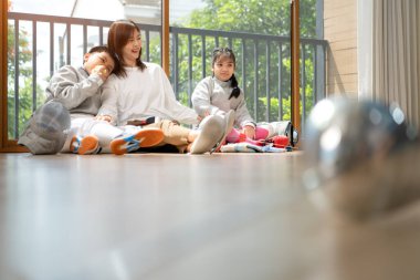 Bir kız ve oğlan, anneleriyle eskrim kıyafetleri içinde yaklaşan müsabakaya hazırlanmak için eskrim antrenmanından önce yiyecek ve spor malzemeleri hazırlıyorlar.