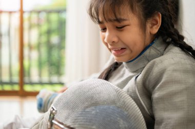 Eskrim kıyafeti giymiş bir kız kenarda oturuyor ve başarısız oyun için hayal kırıklığı yaşıyor.