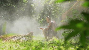 Bahçede sigara içen dövmeli yaşlı bir adam.