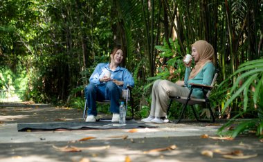 Yerel bir parkta tatilin tadını çıkaran iki genç Müslüman kadın.