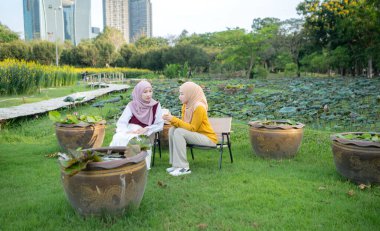 Yerel bir parkta tatilin tadını çıkaran iki genç Müslüman kadın.