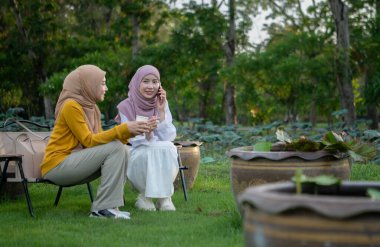 Yerel bir parkta tatilin tadını çıkaran iki genç Müslüman kadın.