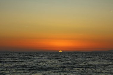 Hırvatistan 'da Adriyatik Denizi' nde yaz günbatımı. Turuncu güneş ufkun yarısına kadar battı bile..