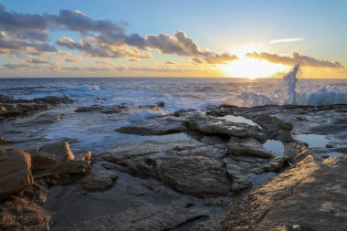 Malta 'da kayalık sahilde gün doğumu dalgalı denizin kıyısında