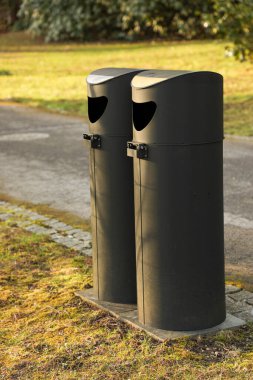 Şehrin Avrupa Parkı 'nda kaldırımın yanında iki sokak konteynırı duruyor..