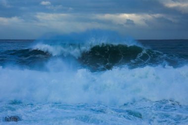 Fırtınalı deniz, büyük dalgalar fışkırtarak sahile vuruyor..