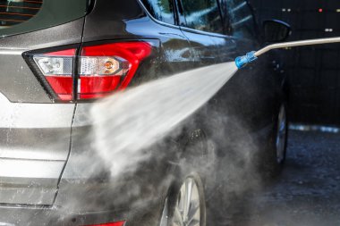 Yüksek basınçlı çamaşır makinesiyle oto yıkamada profesyonel oto yıkama. Temiz, köpüklü su püskürtüleri arabanın yüzeyindeki kiri temizler (araba yıkamada serinin bir kısmı).