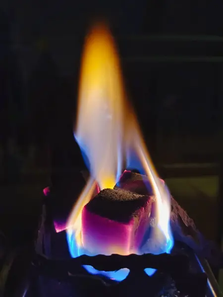 Yanan kömür küplerine yakın çekim yaparak alevler yayarak tabandan sarıya doğru renk eğimlerini maviye dönüştürüyor. Karanlık bir ortamda ateş, ısı ve enerji temaları için ideal.