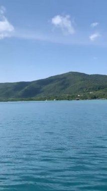 Ada manzarası ve denizdeki dağlar