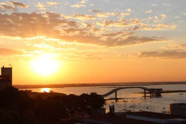 The photo shows a beautiful sunset in the Pantanal, on the border between Brazil and Bolivia. It is possible to see the Paraguay River and the bridge from the city's water collection station. clipart