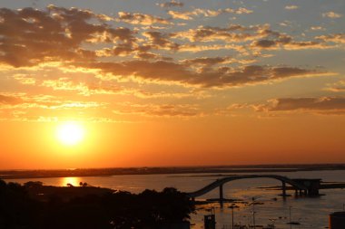 The photo shows a beautiful sunset in the Pantanal, on the border between Brazil and Bolivia. It is possible to see the Paraguay River and the bridge from the city's water collection station. clipart