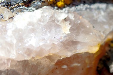 Yarı saydam kuvars dokusuna sahip ham mineral kristalinin makro yakın çekimi, doğal yapıyı, ışıl ışıl yüzeyleri ve dünyevi detayları gösteriyor..