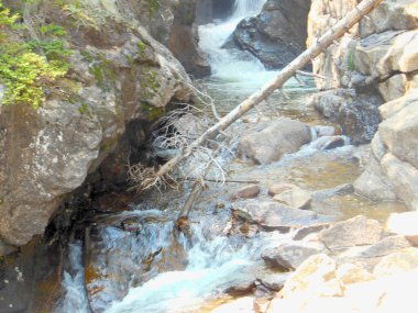 Çağlayarak akan şelaleleri ve düşen dalları olan kayalık bir dere doğanın hareketli engebeli güzelliğini gözler önüne seriyor..