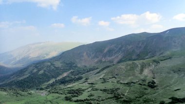 Kayalık Dağ Milli Parkı 'nda sakin bir vadi ve engebeli dağlar batan güneşin yumuşak gölgeleriyle.