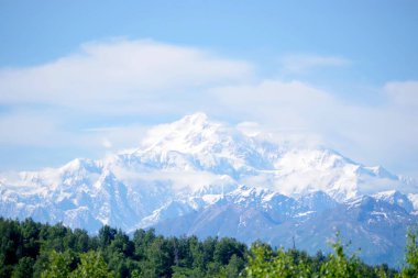 Alaska, Denali Ulusal Parkı 'ndaki eriyen bir buzulun hava görüntüsü çarpıcı mavi eriyen su havuzlarıyla buz ve tortu tabakaları sergiliyor. Görüntü, iklim değişikliğinin devam eden etkilerini ve Alaska buzullarının dönüşümünü vurguluyor