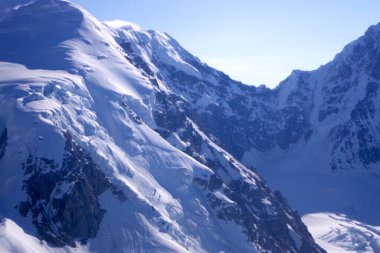 Alaska, Denali Ulusal Parkı 'ndaki eriyen bir buzulun hava görüntüsü çarpıcı mavi eriyen su havuzlarıyla buz ve tortu tabakaları sergiliyor. Görüntü, iklim değişikliğinin devam eden etkilerini ve Alaska buzullarının dönüşümünü vurguluyor
