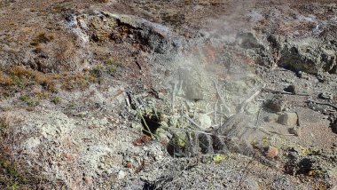 Uçsuz bucaksız mavi gökyüzünün altında dramatik bulutlarla Kilauea Krateri 'nin çarpıcı manzarası. Bu engebeli volkanik arazi yemyeşil bitki örtüsüyle çelişiyor..