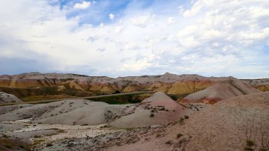 Güney Dakota, Badlands Ulusal Parkı 'ndaki çok renkli popoların ve otlakların arasından manzaralı bir yol esiyor..