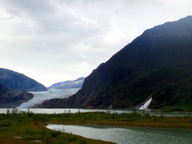 Mendenhall Buzulu ve Nugget Şelalesi 'nin bulutlu manzarası Juneau Alaska' daki doğa yürüyüşü patikasından görülüyor.