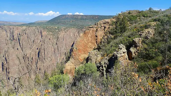 Gunnison Ulusal Parkı 'nın Kara Kanyon' unda kayalık katmanlı kaya oluşumları olan kayalık ve fırça gibi bir arazi.