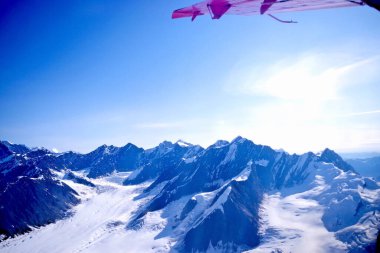 Alaska 'nın dramatik yabanı üzerinde uçarken Denali' nin karla kaplı tepelerinin ve buzullarının geniş hava manzarası.