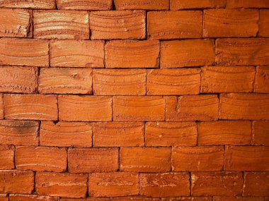 Düzenli bir şekilde düzenlenmiş, dalgalı dokularını ve sıcak renklerini vurgulayan kırmızı tuğlalardan yapılmış bir duvar. Görüntü, yapı malzemelerinin sadeliği ve paslanmışlığını yakalıyor. Sıcaklık ve orijinallik hissi uyandırıyor..