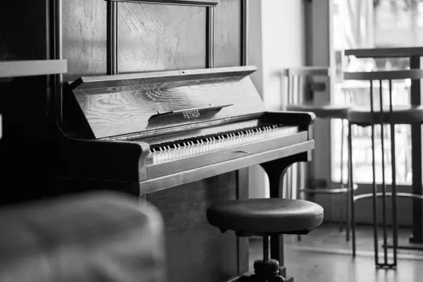 Beyaz sandalyeli eski model bir piyano.
