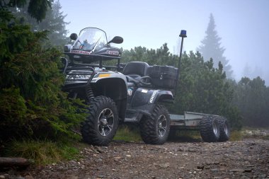 Dağda treyleri olan dörtlü bir araç.