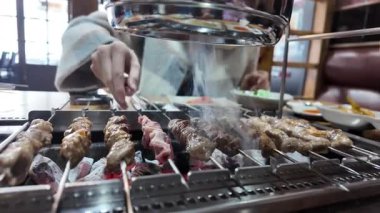 Kız Çin kebabı pişiriyor, otomatik şiş. Yüksek kalite 4k görüntü