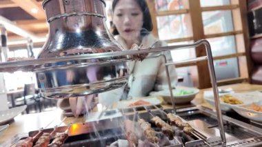 Kız Çin kebabı pişiriyor, otomatik şiş. Yüksek kalite 4k görüntü