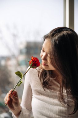 Kırmızı gül kokan Asyalı kız. Yüksek kalite fotoğraf