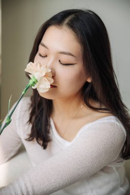 Beyaz bluz içinde beyaz gül kokan Asyalı kız. Yüksek kalite fotoğraf