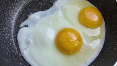 Kahvaltıda yumurta pişirmek için sıcak demir tavada yumurta pişirme videosunu kapat. Yüksek kalite 4k görüntü
