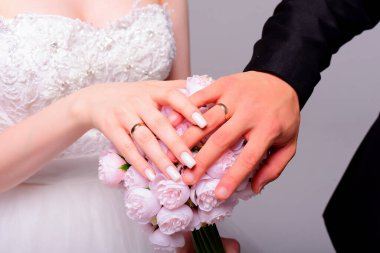 Gelin ve damadın elleri düğün buketinde yüzüklerle. Evlilik kavramı. Yüksek kalite fotoğraf