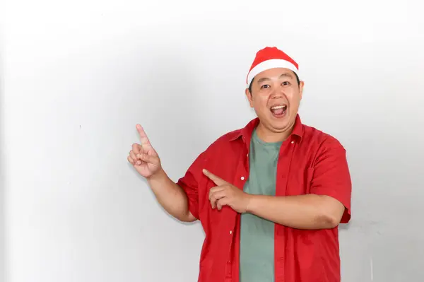 Noel Baba şapkalı mutlu adam elini boşluğa uzatıyor.