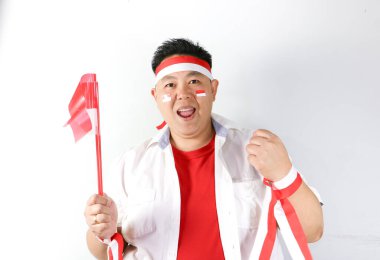 Mutlu Endonezyalı Adam Evet hareketi yapıyor ve Bağımsızlık Günü Partisi sırasında Endonezya Bayrağı taşıyor