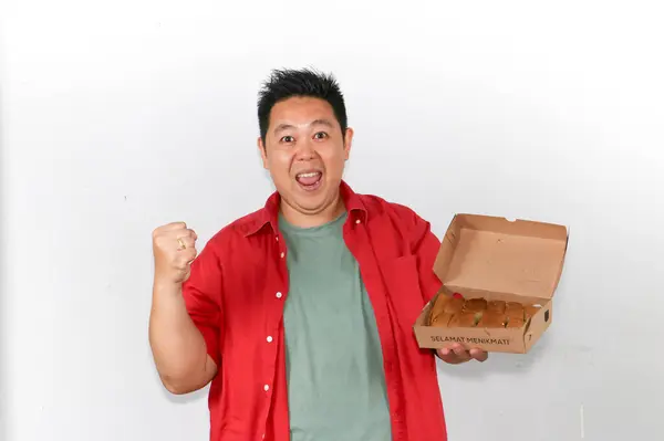 Bir kutu lezzetli Endonezyalı Martabak tutan ve EVET hareketi yapan mutlu adam.